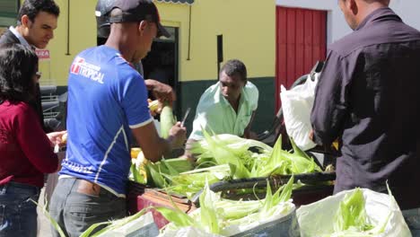 Man-prepares-corn-to-be-sold-at-the-morning-market,-in-Capelinha,-Minas-Gerais,-Brazil