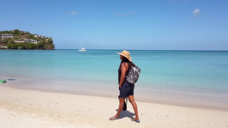 Ein-Tourist-Geht-Am-Strand-Entlang,-Im-Hintergrund-Brechen-Die-Wellen