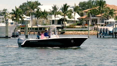 Barco-De-Pesca-Con-Hombres---Mujeres-Recorriendo-El-Canal-De-Bolsillo-Del-Manatí-En-Stuart-Florida,-Diversión-Recreativa-En-Las-Temporadas-De-Vacaciones