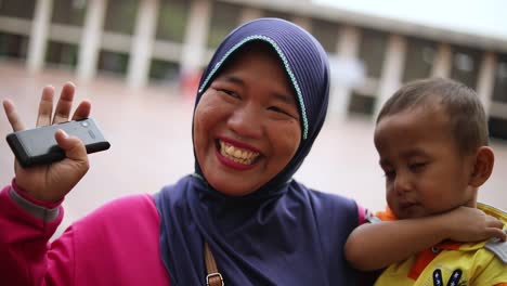 Slow-Motion-shot-of-a-happy-Muslim-Woman-in-an-Asian-Country-waving-at-the-camera