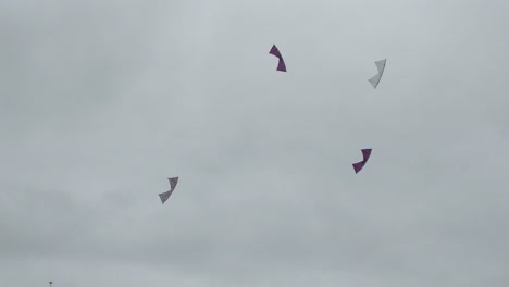 Cuatro-Personas-Volando-Cometas-Acrobáticas-Altamente-Maniobrables-En-Coordinación-En-Un-Día-Nublado-Y-Ventoso-En-Un-Campo-De-Hierba-En-Fort-Casey