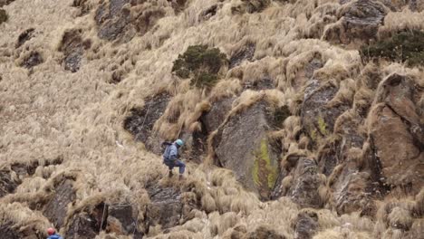 Himalayan-Mountaineers-at-rocky-mountain-Himalayan-mountaineers-on-their-way-to-reach-their-destination-with-their-backpacks---essential-goods---passing-through-rocky-mountains-Uttarakhand,-India