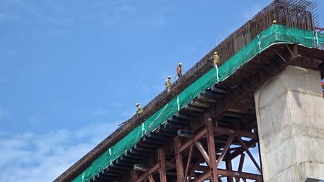 Trabajadores-De-La-Construcción-Que-Trabajan-En-Altura-Instalando-Barras-De-Refuerzo-Y-Formando-Trabajos-En-El-Sitio-De-Construcción