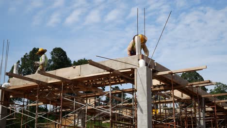 Bauarbeiter,-Die-Auf-Der-Baustelle-Holzschalungen-Und-Regenwasserrohre-Installieren