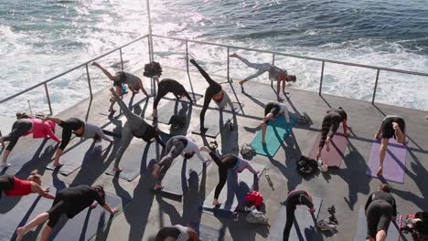 Una-Clase-De-Yoga-En-Grupo-Al-Aire-Libre-Temprano-En-La-Mañana-En-La-Playa-De-Bondi-Junto-Al-Océano