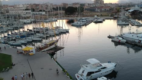 Nov-2019,-Palermo,-Italy:-drone-flying-above-Palermo's-Pier-in-the-late-afternoon,-with-people-walking-on-the-wharf