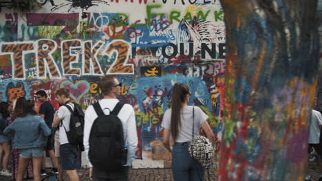 Tourists-at-the-Lennon-Wall-in-Prague,-moving-shot,-Prague,-Czech-Republic