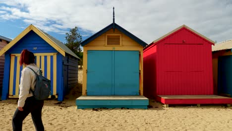 Tourists-walking-and-taking-photo-at-Brighton-Bathing-Boxes,-Melbourne,-Australia