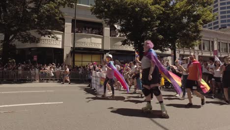 Seattle-Public-School-employees-and-students-participating-in-the-Seattle-LGBTQ-parade,-School-bus,-waving-rainbow-flags