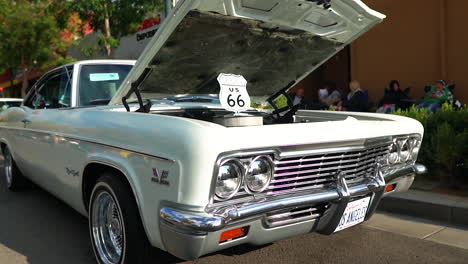 Blanco-Crema-Clásico-Chevy-Impala-En-Exhibición-Con-El-Capó-Abierto,-Pedestal