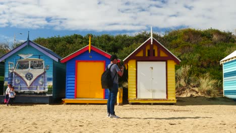 Tourists-walking-and-taking-photo-at-Brighton-Bathing-Boxes,-Melbourne,-Australia