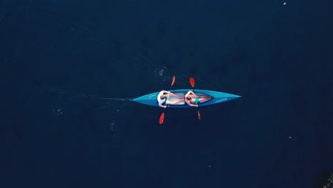 Drohnenaufnahme-Eines-Paares-In-Einem-Kajak-Auf-Dem-Meer,-Das-Von-Links-Nach-Rechts-Fährt,-Ohne-Dass-Land-In-Sicht-Ist