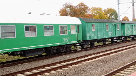 Panoramablick-Auf-Eine-Komposition-Grüner-Personenschlafwagen-Auf-Einem-Bahnsteig-In-Einer-Kleinstadt