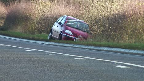 Ein-Kleines-Rotes-Auto,-Das-Mit-Polizeiband-Bedeckt-War,-Nachdem-Es-In-Der-Nähe-Von-Melton-Mowbray-In-Leicestershire,-England,-Großbritannien,-In-Eine-Hecke-Krachte