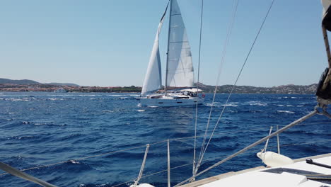 POV-of-a-man-greets-a-near-passing-sailboat-at-La-Maddalena-National-Park,-Sardinia