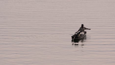 Pescador-Perfilando-Mientras-Lanza-Y-Saca-Su-Red-En-El-Río-Antes-Del-Anochecer,-En-Cámara-Lenta