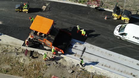 Luftaufnahme-Von-Arbeitern,-Die-Mit-Einer-Asphaltiermaschine-Eine-Straße-Erneuern