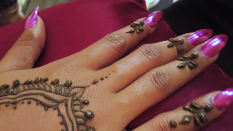 Primer-Plano-De-Una-Mano-De-Mujer-Elegante-Y-Cuidada-Con-Uñas-Rosadas-Que-Recibe-Un-Tatuaje-Tradicional-De-Henna-En-Little-India-En-Singapur