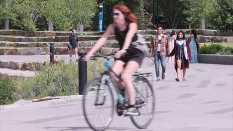 Cyclists,-pedestrians,-scooters-on-urban-pathway-on-warm-summer-day