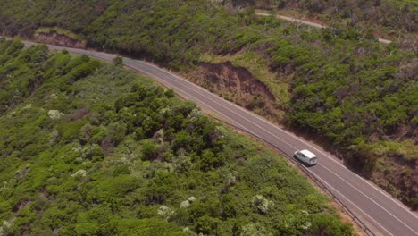 Dron-Aéreo-Siguiendo-A-Una-Camioneta-Que-Navega-Por-La-Carretera-Costera-Del-Gran-Océano