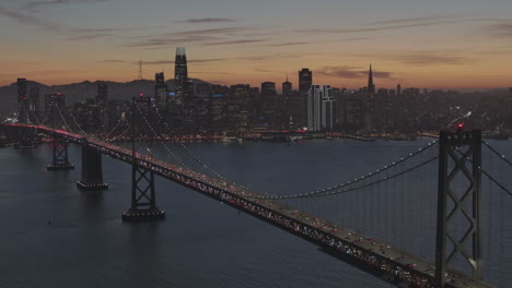 A-suspension-bridge-over-water-with-traffic-that-is-near-a-large-city