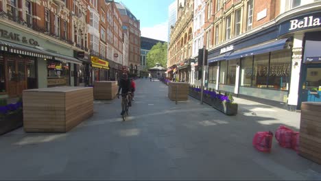 Follow-Shot-Of-Two-Adult-Male-Cyclists-Riding-Through-Irving-Street-During-Lockdown-In-London