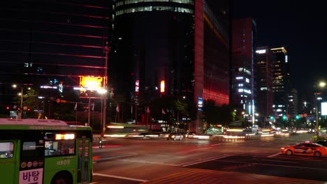 Lapso-De-Tiempo-De-La-Encrucijada-De-La-Estación-De-Gangnam,-Senderos-Ligeros-Y-Tráfico-Nocturno-De-La-Calle-Principal-De-Seúl,-Pan-A-La-Izquierda