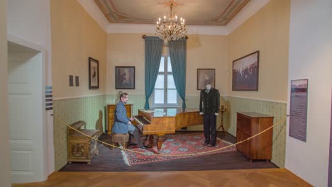 Ein-Gut-Gekleideter-Mann-Hört-Auf,-Klavier-Zu-Spielen,-Und-Verlässt-Die-Ausstellung-Im-Hugo-Wolf-Museum-In-Slovenj-Gradec,-Slowenien