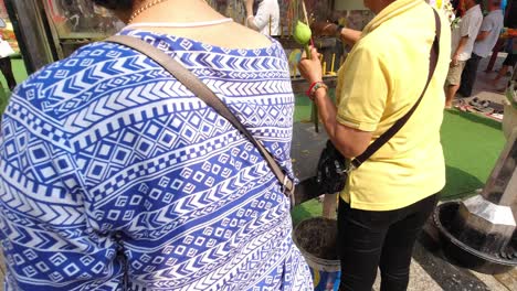 Mujer-Tailandesa-Encendiendo-Una-Vela-En-El-Templo-Wat-Pho-En-Bangkok