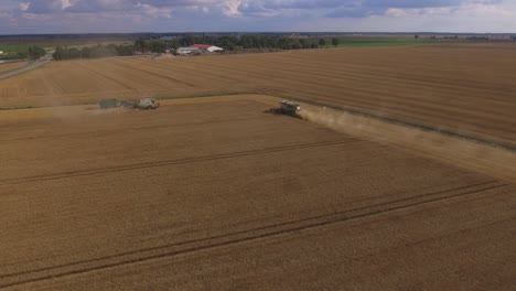 Zwei-Mähdrescher-Und-Ein-Traktor-Mit-Anhänger-Arbeiten-Auf-Landwirtschaftlichen-Feldern