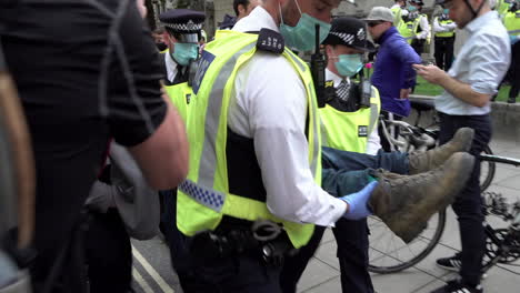 Oficiales-Metropolitanos-De-Londres-Llevan-Detenidos-A-Manifestantes-Por-El-Cambio-Climático-De-La-Rebelión-De-Extinción-A-Través-De-Líneas-De-Cordón-Policial-Durante-Las-Protestas-Frente-Al-Parlamento-En-Westminster-Durante-La-Pandemia-Del-Coronavirus