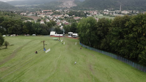 Tracking-Aerial-Shot-Of-A-Grass-Skier-Skiing-In-A-Downhill-Competition,-Alpine-Sport-In-Summer