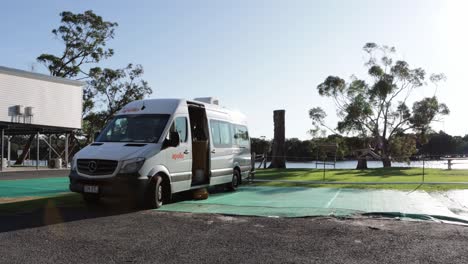 Travel-rental-van-with-open-doors-at-Jervis-Bay-Lions-camping-ground,-Handheld-Shot