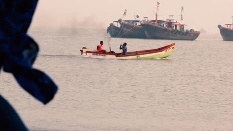 Two-Indian-fisherman-sailing-in-small-wooden-motor-boat-in-middle-of-the-ocean-during-sunset-and-enjoying-evening-in-small-boat-video-background-in-full-HD-in-mov