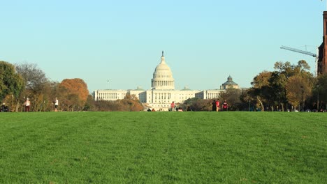 Menschen,-Die-Im-Herbst-In-Washington,-USA,-Auf-Dem-Grünen-Rasen-Mit-Dem-Kapitol-Der-Vereinigten-Staaten-Im-Hintergrund-Spazieren-Gehen-Und-Spaß-Haben