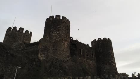 Historical-medieval-Conwy-castle-landmark-aerial-view-low-angle-right-dolly