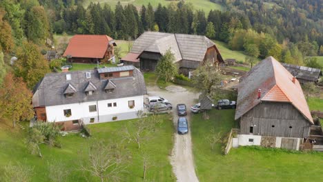 Cars-parked-outside-big-wood-houses,-Prevalje,-Slovenia