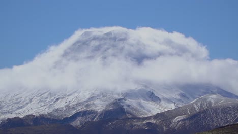 Clouds-roll-over-snowy-peaks-in-the-arthurs-pass-of-New-Zealand