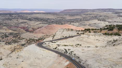 Slow-motion-shot-of-camper-van-driving-in-incredible-landscape-in-Utah,-USA