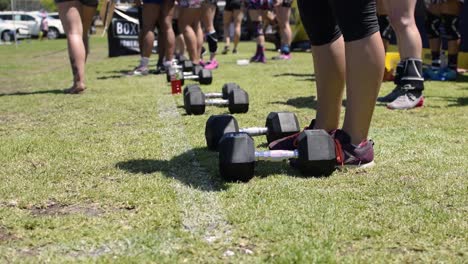 Toma-De-Una-Línea-De-Pesas-Mientras-Un-Grupo-De-Atletas-Femeninas-Se-Preparan-Para-Una-Competencia-De-Crossfit