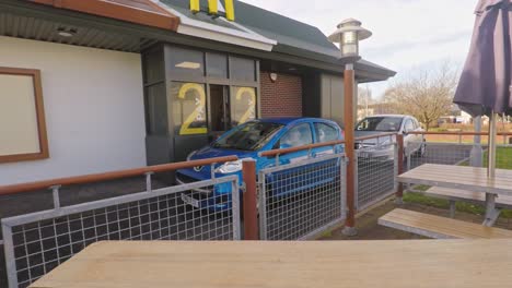 La-Gente-Que-Paga-En-El-Mcdonalds-Conduce-A-Través-Del-Famoso-Restaurante-Golden-Arches,-Ahora-Abierto-Las-24-Horas,-Los-7-Días-De-La-Semana,-Que-Sirve-Comida-Rápida-En-El-Centro-De-La-Ciudad