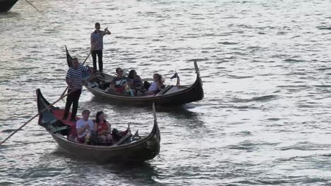 Tourists-ride-two-Gondolas-on-the-busy-water-of-Venice-in-Italy