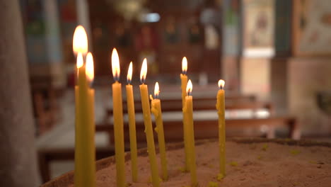 Velas-Encendidas-Con-Trozos-De-Cera-En-El-Fondo-De-Un-Tazón-De-Arena-Dentro-De-La-Iglesia-Ortodoxa-Griega-De-Madaba-St-George,-100-Fotogramas-Por-Segundo