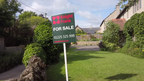 Fotografía-De-Camión-De-Izquierda-A-Derecha-Del-Cartel-Inmobiliario-Británico-&quot;en-Venta&quot;-En-Un-Día-Soleado-De-Verano-Con-Una-Casa-De-Pueblo-Rural-En-Segundo-Plano.