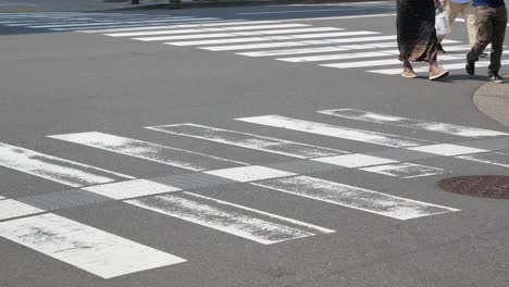 Zooming-in-to-the-foot-of-people-with-view-of-the-street-crossing-way-with-many-people-are-crossing-the-road-in-the-city-center-of-Tokyo,Japan-in-day-time-4K-UHD-video-movie-footage-short