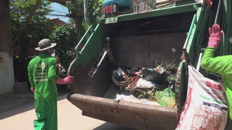 Plano-Medio-De-Trabajadores-Llenando-Un-Camión-De-Basura