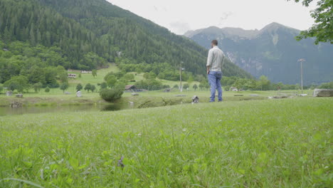 Man-looks-at-the-mountain-in-front-of-a-lake-in-the-Italian-Alps-4K-ProRes-422