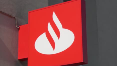 Toma-En-Cámara-Lenta-A-La-Izquierda-Del-Cartel-Del-Banco-Santander-En-La-Calle