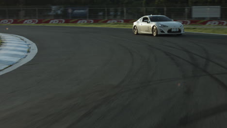 Coche-De-Carreras-Blanco-Conduciendo-Por-Una-Pista-De-Deportes-De-Motor