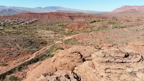 Drone-flies-over-person-sitting-on-rock-formations